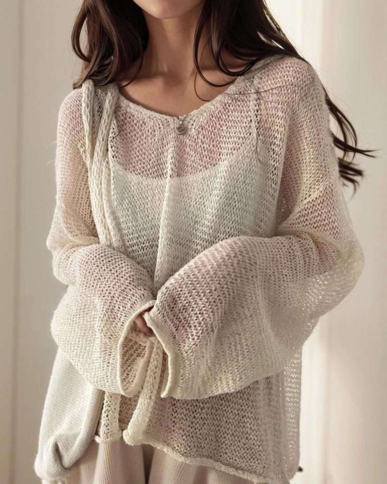 Un elegante cárdigan de mujer con un patrón calado, mangas largas y un elegante escote redondo.