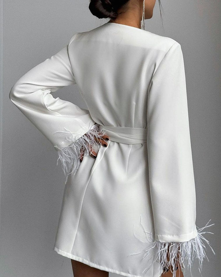 Vestido corto con mangas largas, lazo ajustable y detalles elegantes de plumas