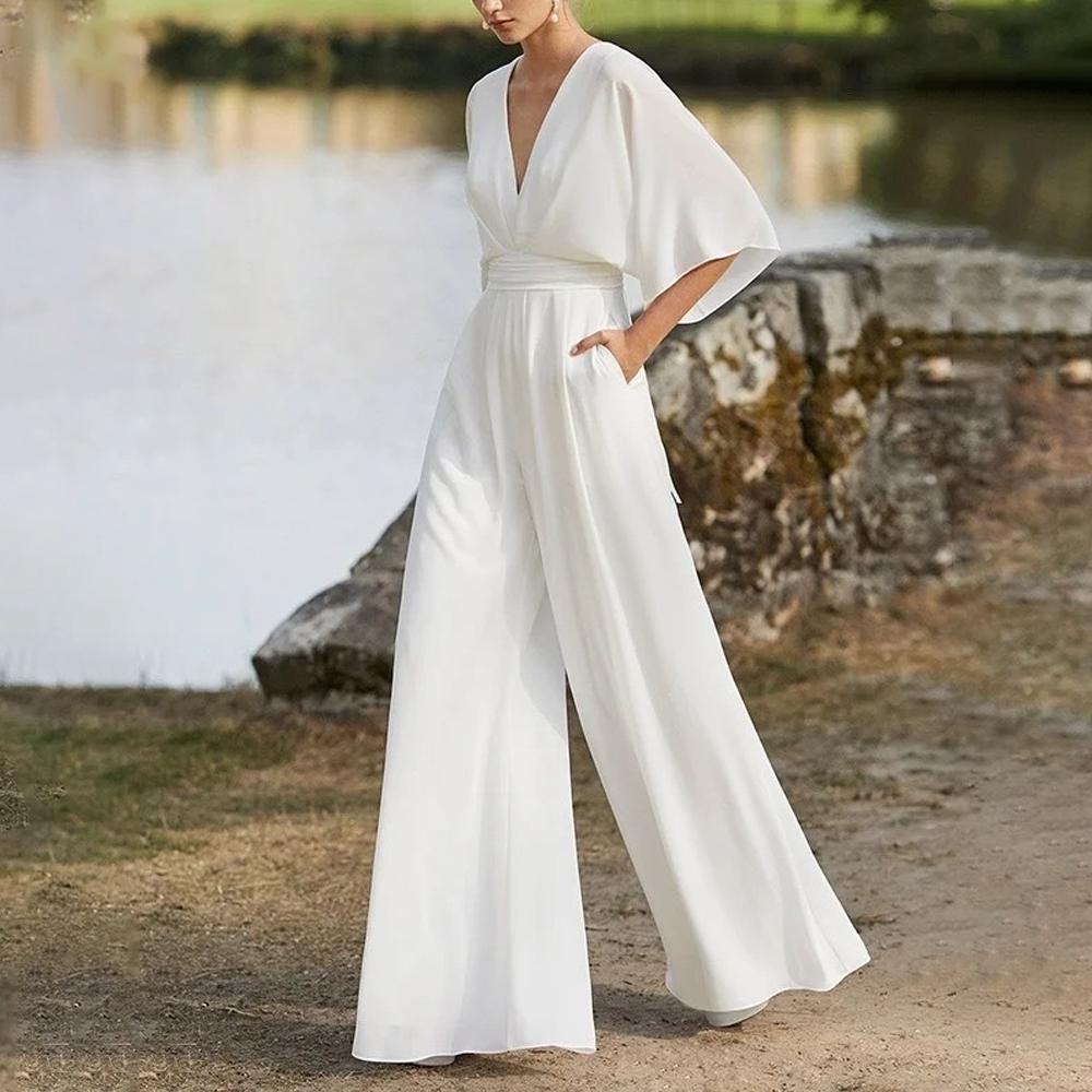 Mono elegante de mujer con escote pronunciado mangas amplias y pantalón ancho