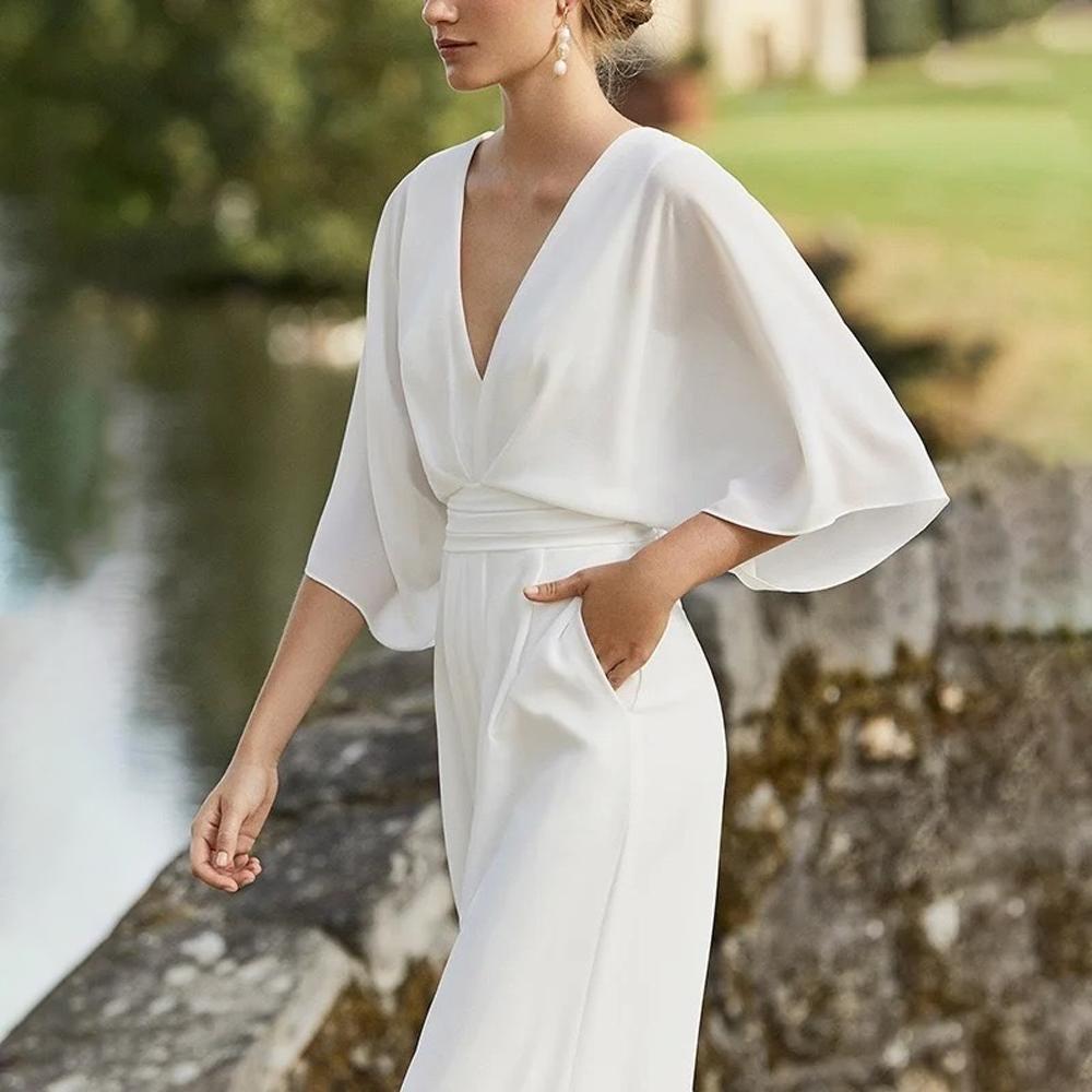 Mono elegante de mujer con escote pronunciado mangas amplias y pantalón ancho